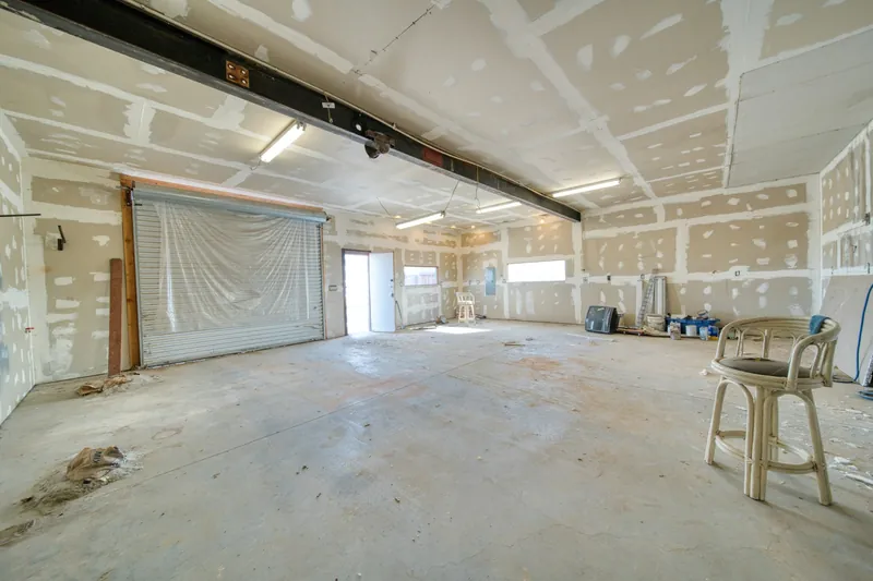 Large room with boarded walls and ceiling, joints filled and awaiting paint
