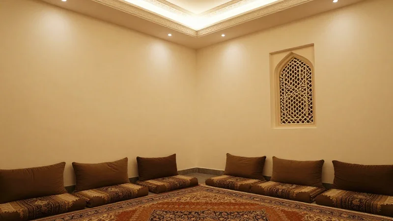 Spacious seating room with sofas along the walls, carved screen panels and pendant lanterns