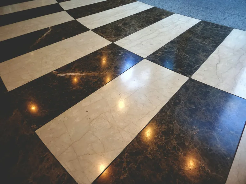 Polished black and cream marble floor in a checkerboard pattern